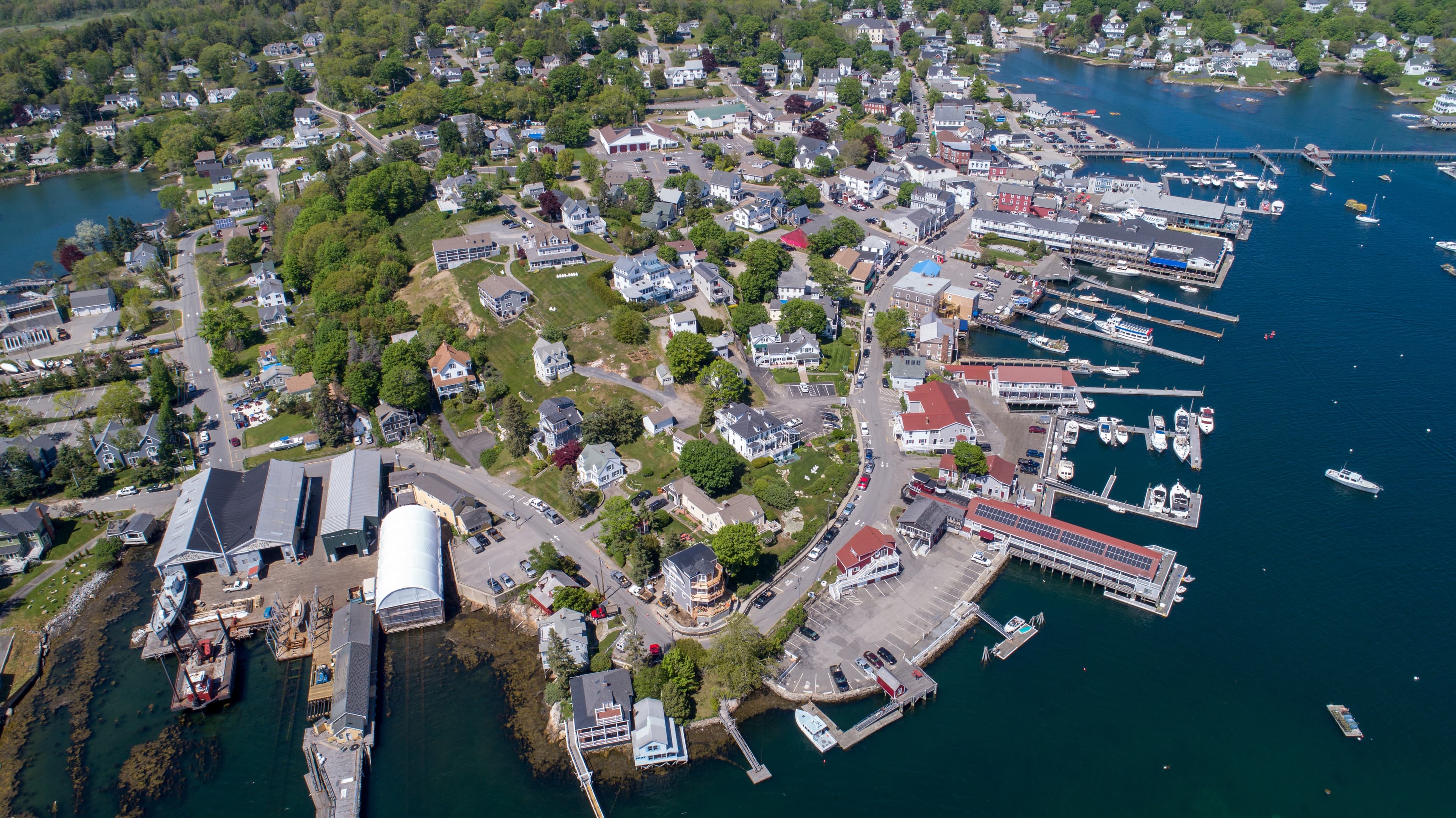 Aerial view of a harbor town with numerous docks lining the edge of the water