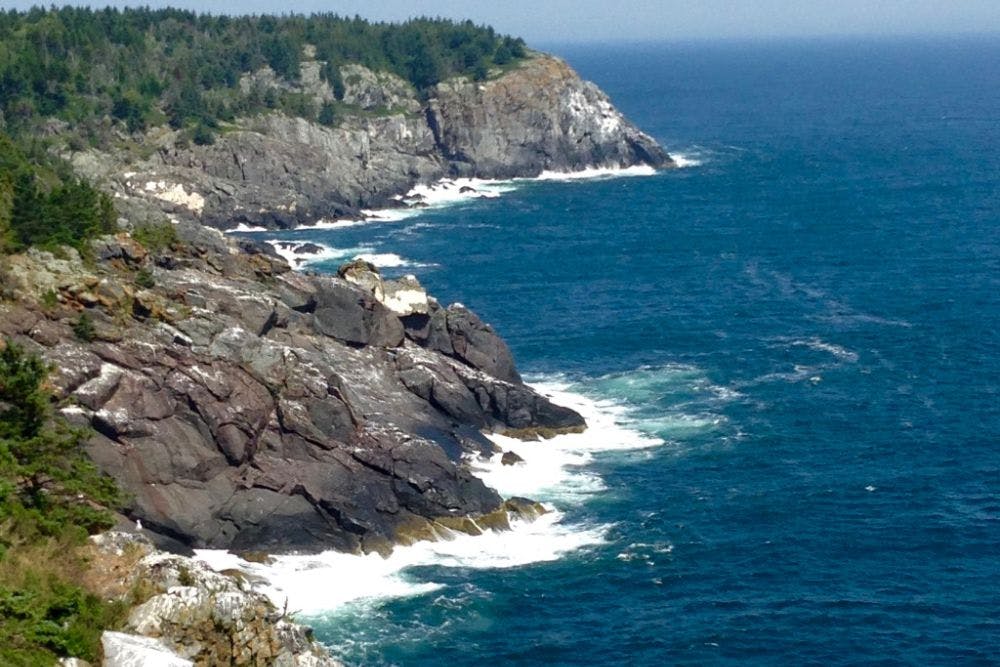 Aerial view of expansive rocky cliffs at waters edge